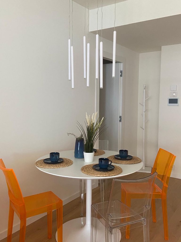 Zona pranzo sedie design arancioni appartamento waterfront genova