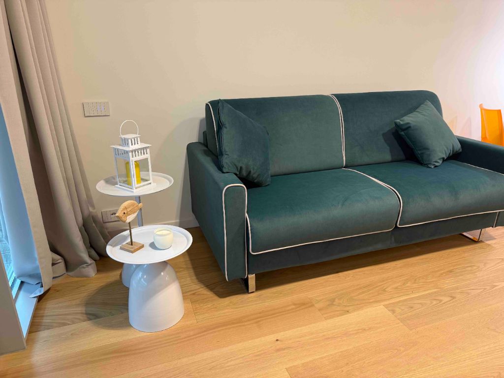 Soggiorno moderno divano verde acqua vista mare appartamento